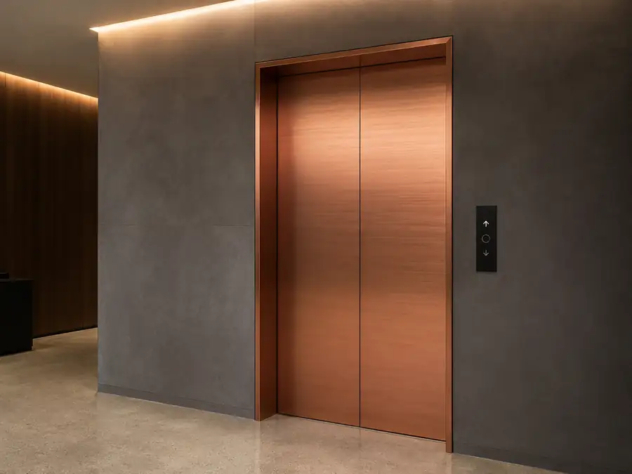 Puerta de ascensor forrada con vinilo arquitectónico de efecto metal por Pingraf